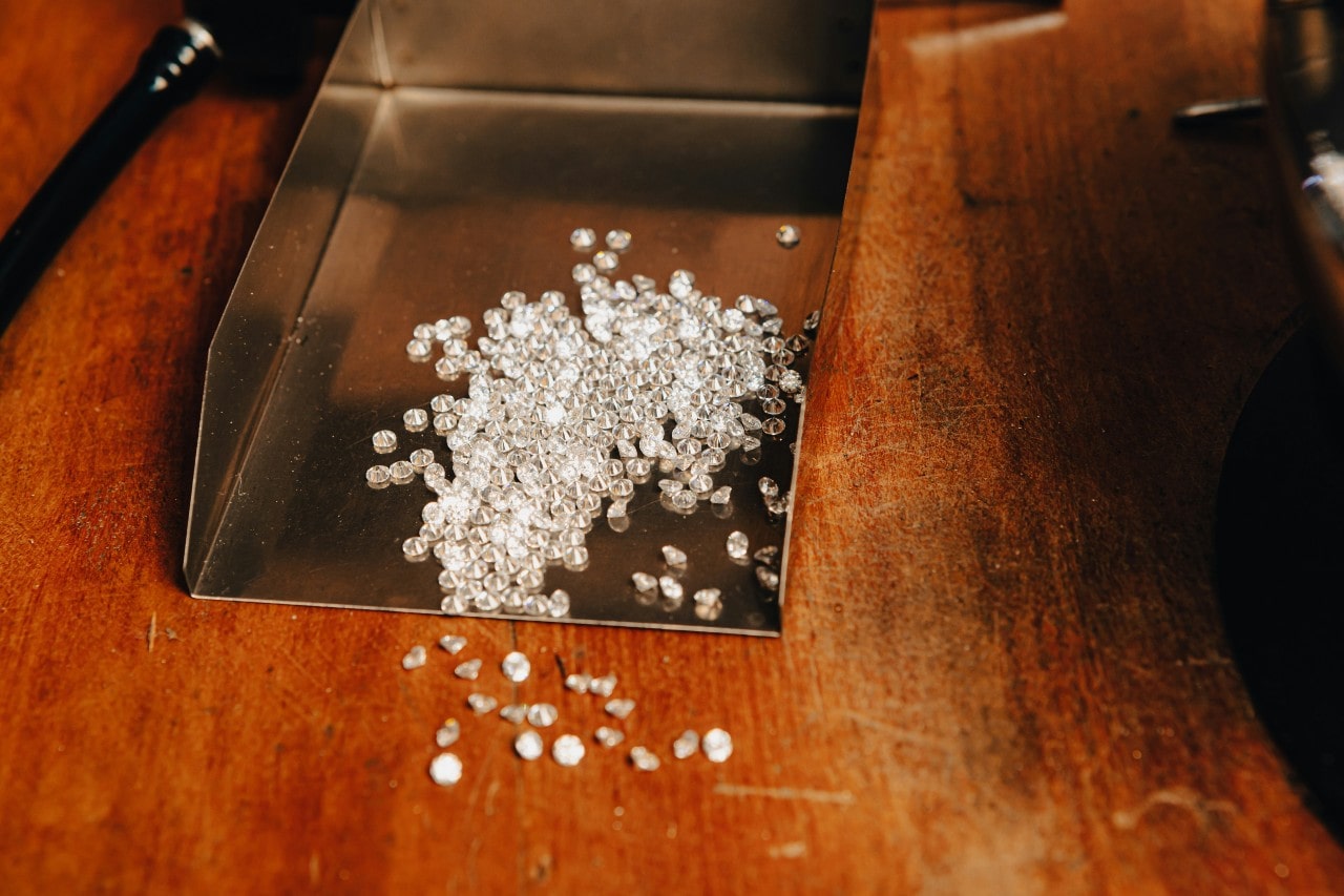 an assortment of round cut diamonds in a metal box